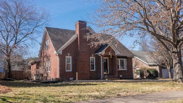 view of front of house with a front yard, a chimney, fence, and brick siding