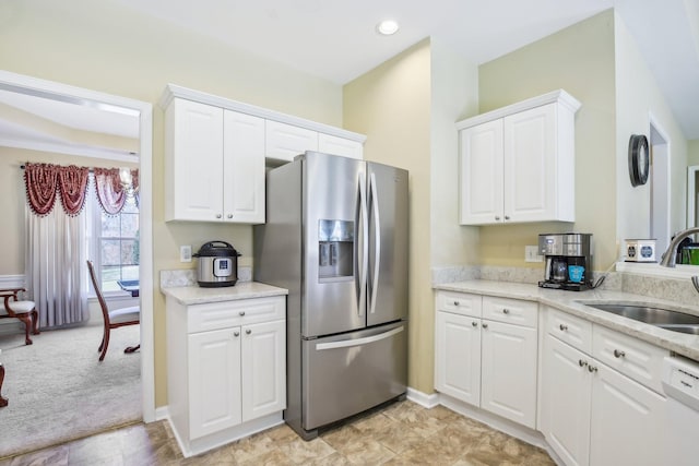 kitchen with white cabinetry, white dishwasher, a sink, light stone countertops, and stainless steel fridge with ice dispenser