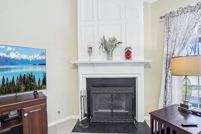 details featuring a fireplace with flush hearth, baseboards, and carpet flooring