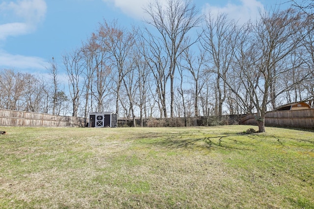 view of yard with a shed, an outdoor structure, and a fenced backyard