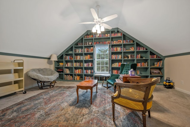 sitting room with built in shelves, carpet flooring, vaulted ceiling, ceiling fan, and baseboards