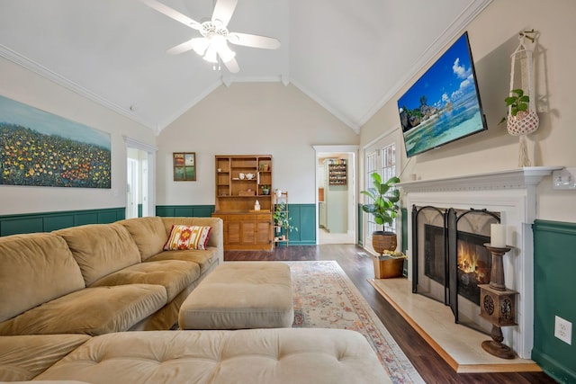 living area featuring a ceiling fan, ornamental molding, wood finished floors, high vaulted ceiling, and a high end fireplace