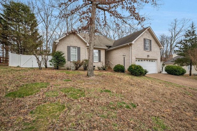 view of front facade with an attached garage, brick siding, fence, driveway, and crawl space