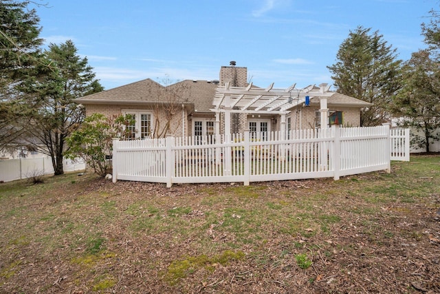 rear view of house featuring brick siding, a patio, a chimney, a pergola, and fence private yard