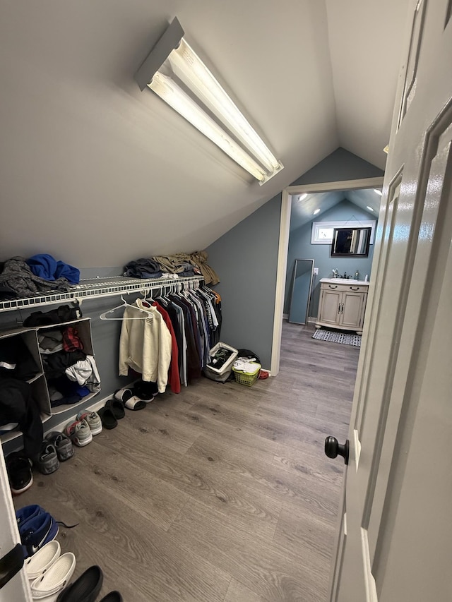 spacious closet with vaulted ceiling and wood finished floors