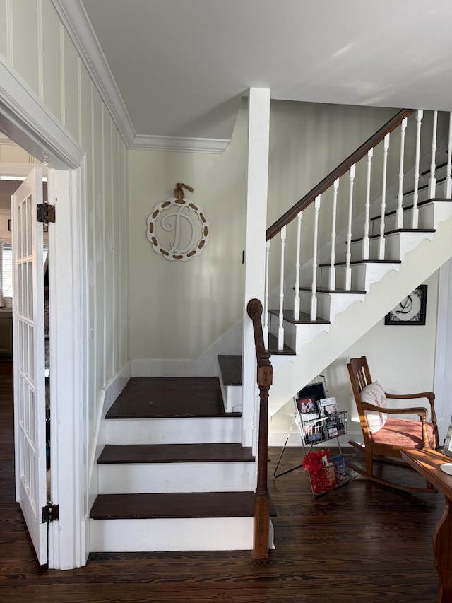 staircase featuring baseboards, wood finished floors, and crown molding