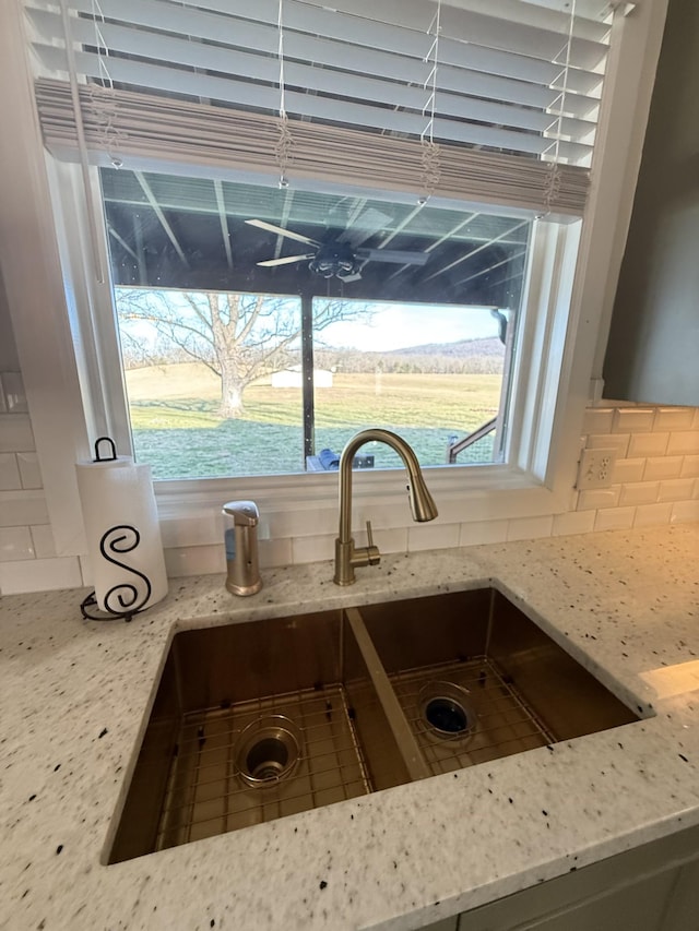 details with tasteful backsplash, light stone counters, and a sink