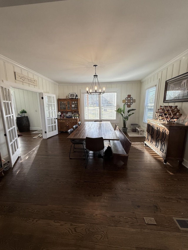 dining area featuring crown molding, french doors, dark wood-style flooring, and a notable chandelier