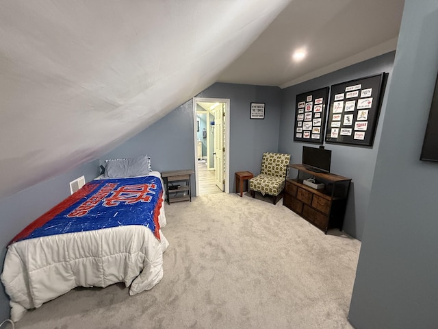 bedroom featuring carpet, visible vents, lofted ceiling, and ensuite bathroom