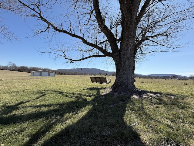 view of yard with an outbuilding and a rural view