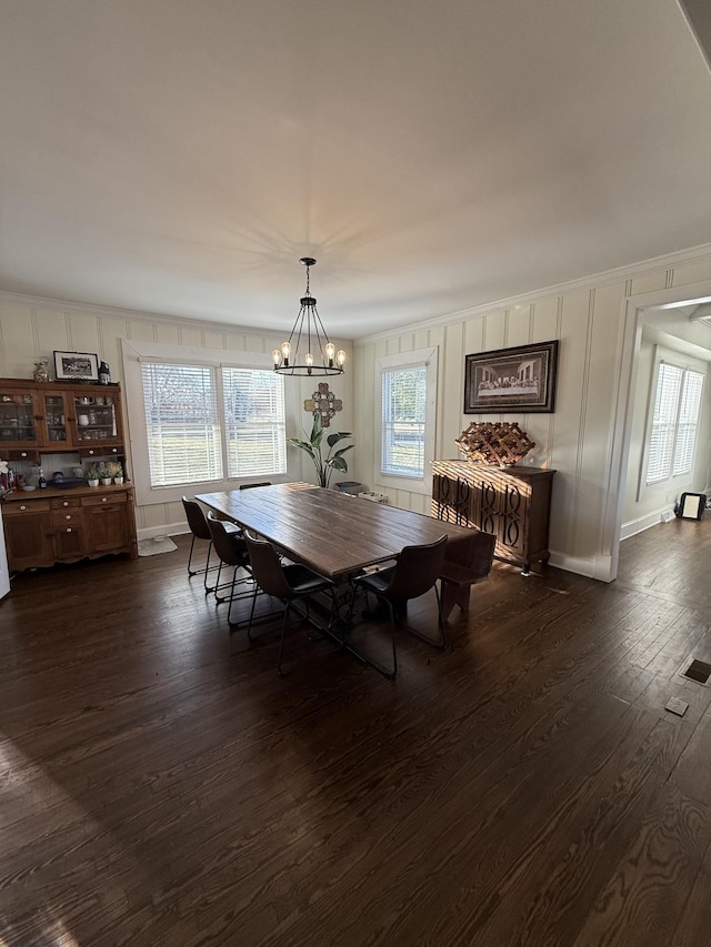 dining space with dark wood-style floors, a wealth of natural light, and crown molding