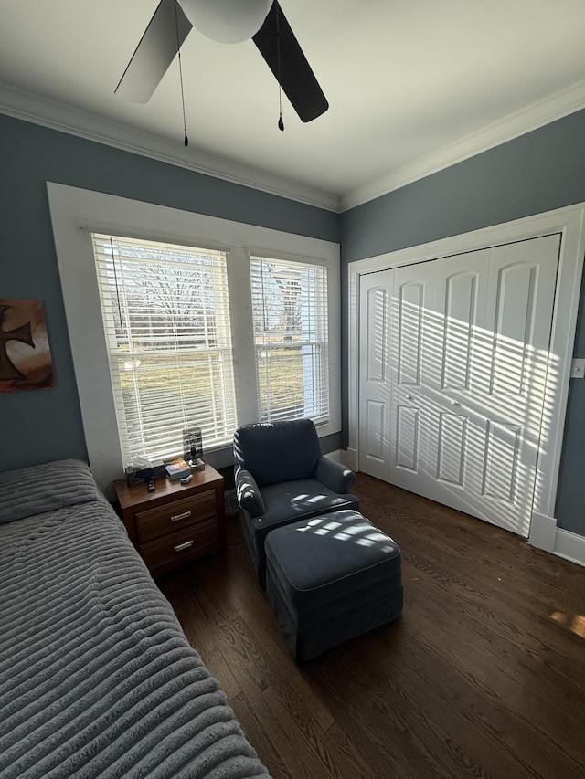 bedroom with baseboards, a ceiling fan, ornamental molding, wood finished floors, and a closet