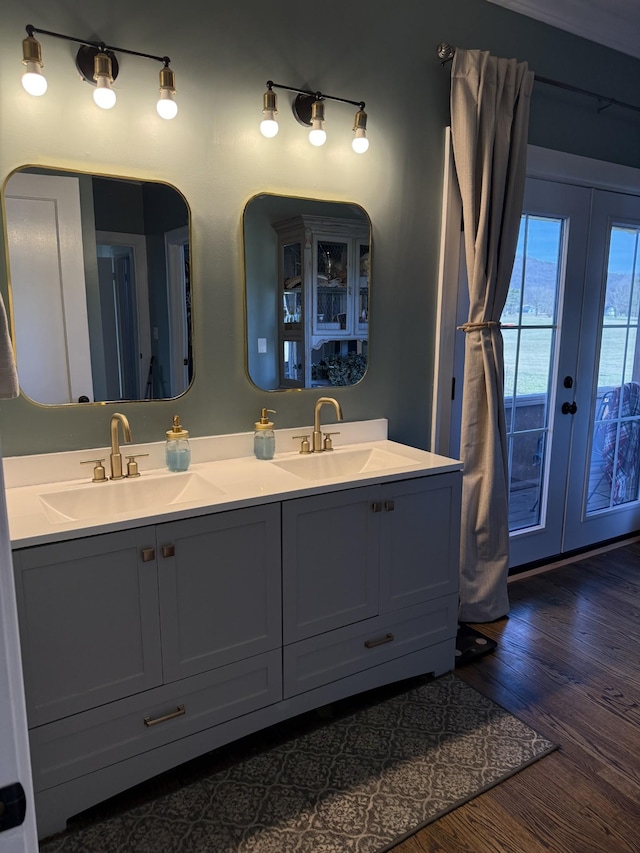 bathroom featuring double vanity, french doors, a sink, and wood finished floors