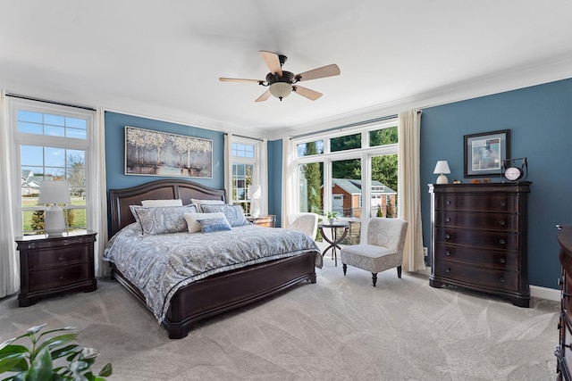 bedroom with ornamental molding, a ceiling fan, carpet flooring, and multiple windows