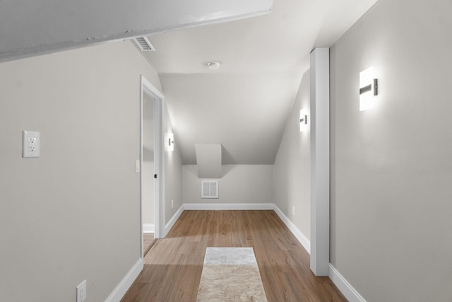 additional living space featuring baseboards, visible vents, and wood finished floors