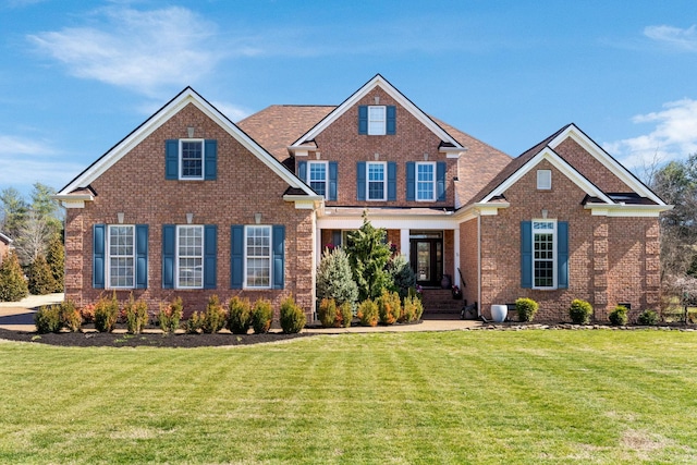 view of front of home featuring a front lawn and brick siding