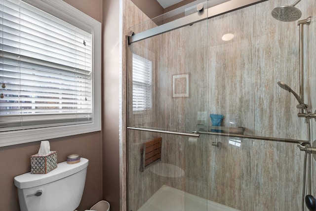 bathroom featuring a shower stall and toilet