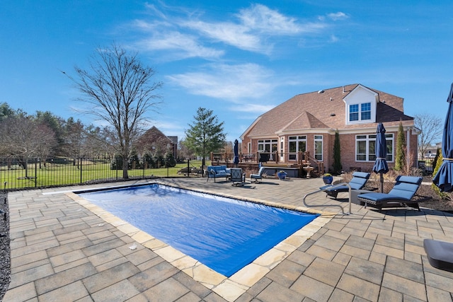 view of pool with a patio area, fence, a wooden deck, and a fenced in pool