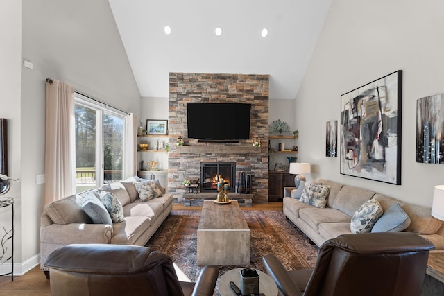 living area featuring high vaulted ceiling, a fireplace, wood finished floors, and baseboards