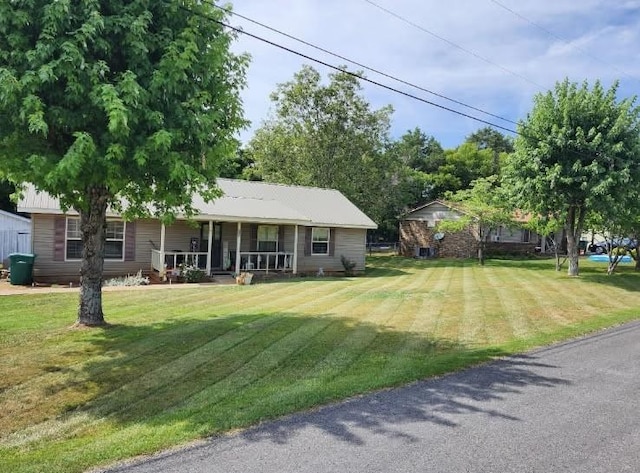 ranch-style home featuring covered porch and a front lawn