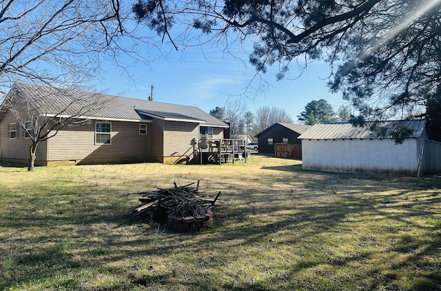 view of yard featuring a deck and an outdoor structure