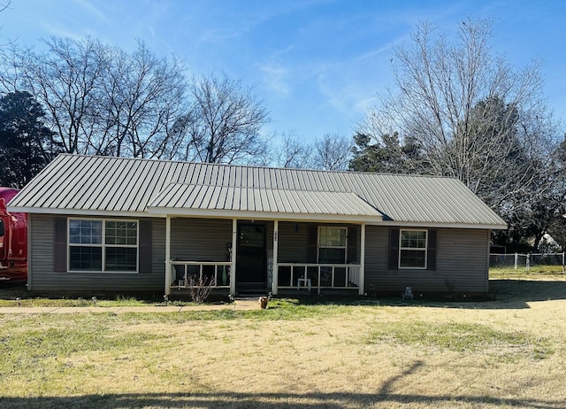 single story home with covered porch, metal roof, and a front yard