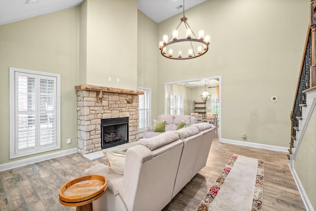 living area with a stone fireplace, stairway, wood finished floors, and a wealth of natural light