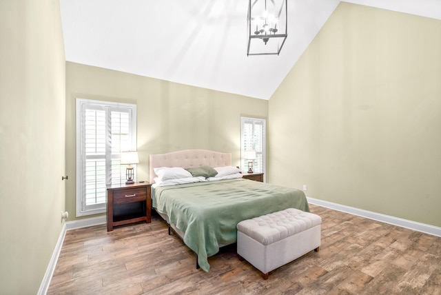 bedroom featuring high vaulted ceiling, baseboards, and wood finished floors