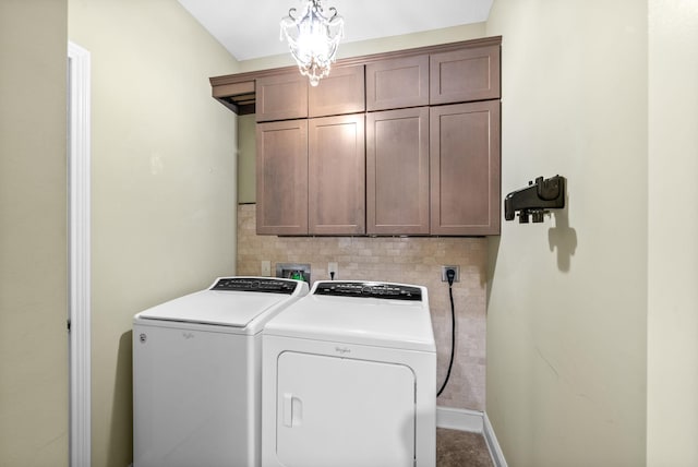 laundry area with cabinet space, baseboards, washer and clothes dryer, and a chandelier