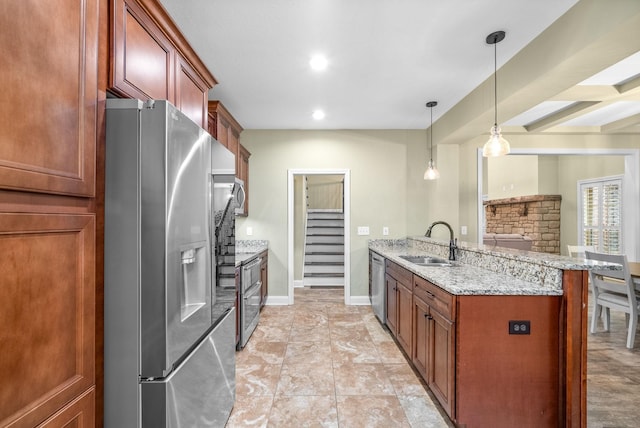 kitchen with a peninsula, a sink, baseboards, appliances with stainless steel finishes, and light stone countertops