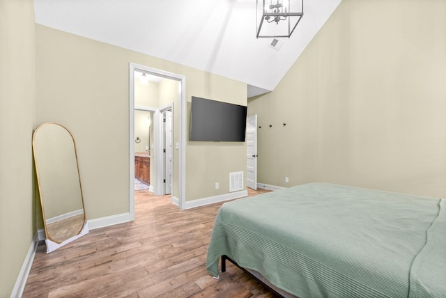 bedroom with lofted ceiling, visible vents, light wood-style flooring, and baseboards