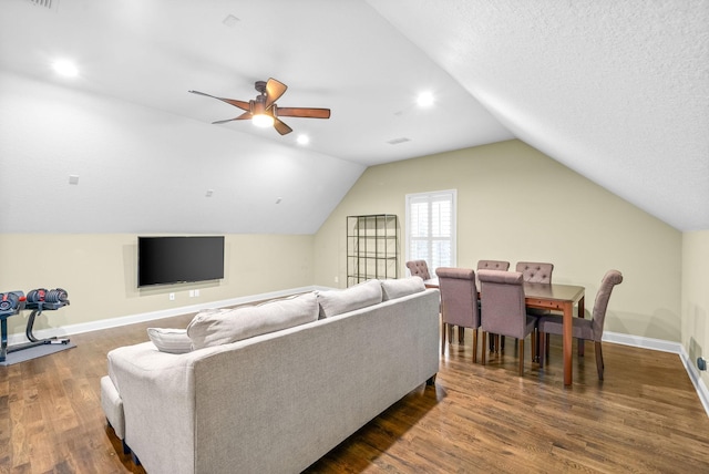 living area featuring lofted ceiling, a ceiling fan, a textured ceiling, wood finished floors, and baseboards