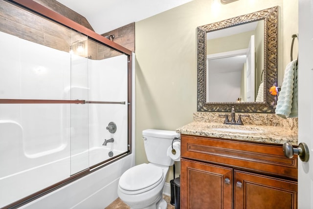 bathroom with enclosed tub / shower combo, vanity, and toilet