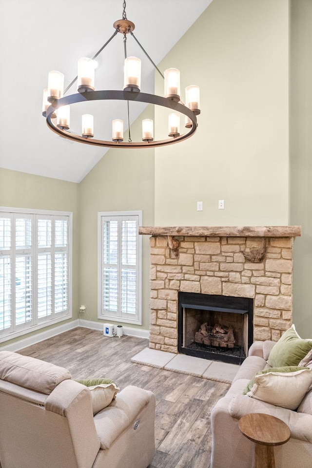 living room with a fireplace, high vaulted ceiling, a notable chandelier, and wood finished floors