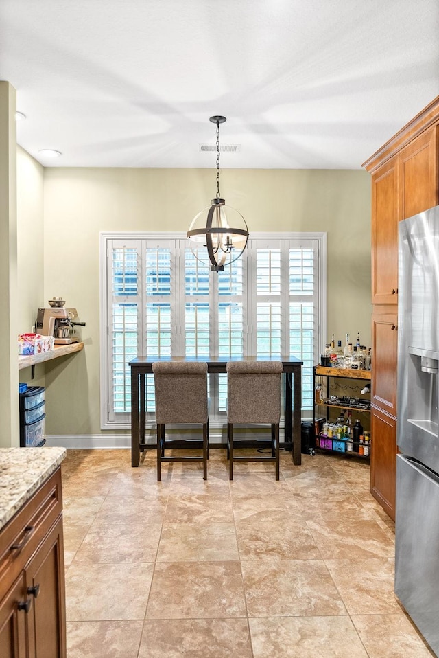 dining room with visible vents, baseboards, a wealth of natural light, and an inviting chandelier