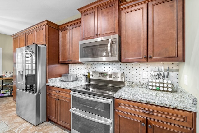 kitchen with stainless steel appliances, brown cabinets, backsplash, and light stone countertops