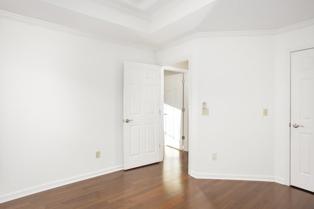 unfurnished bedroom featuring a raised ceiling, crown molding, baseboards, and wood finished floors