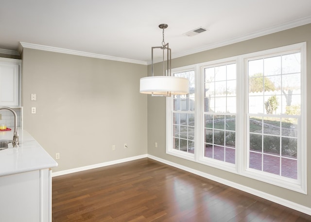 unfurnished dining area with crown molding, visible vents, dark wood finished floors, and a sink