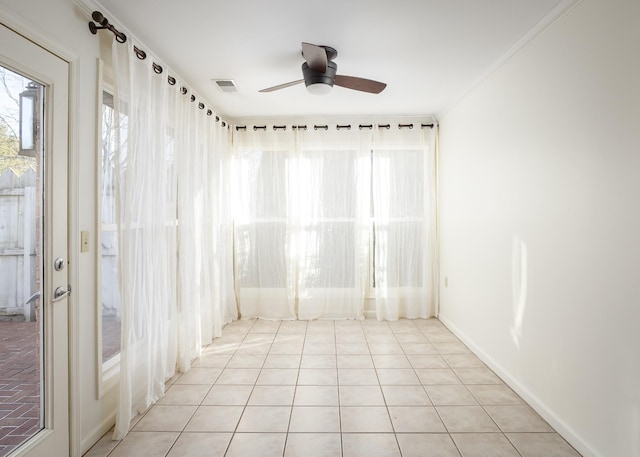 spare room with ornamental molding, plenty of natural light, visible vents, and a ceiling fan