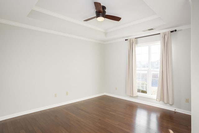 empty room featuring plenty of natural light, a raised ceiling, and visible vents