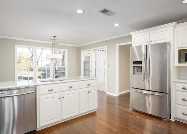 kitchen with visible vents, dark wood finished floors, appliances with stainless steel finishes, crown molding, and a sink