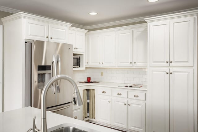 kitchen featuring stainless steel appliances, white cabinets, light countertops, tasteful backsplash, and crown molding