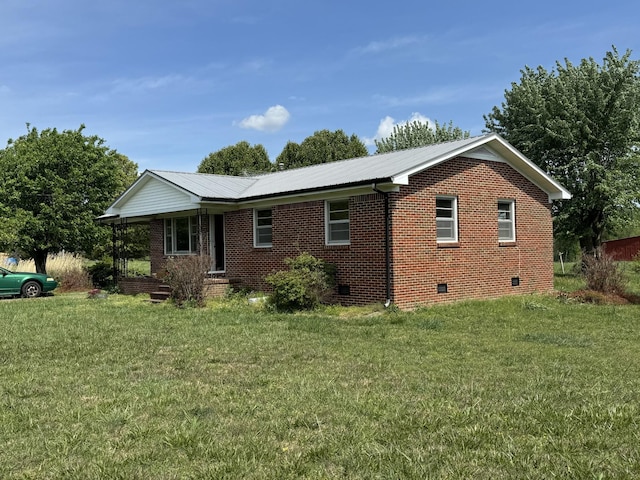 view of side of home featuring crawl space, metal roof, a lawn, and brick siding