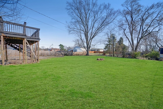 view of yard featuring a deck, stairway, and fence