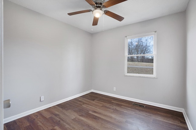 unfurnished room featuring dark wood-type flooring, visible vents, baseboards, and a ceiling fan