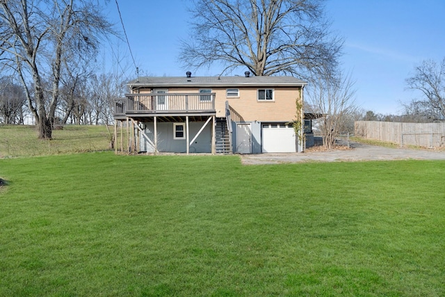 back of property featuring a lawn, stairway, an attached garage, a deck, and driveway