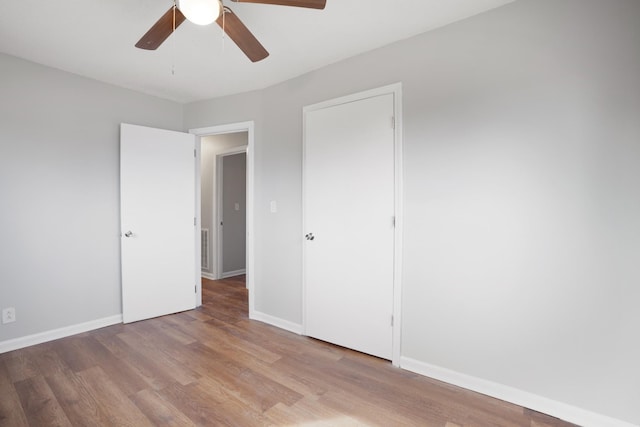 unfurnished bedroom with a ceiling fan, baseboards, and light wood finished floors