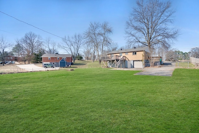 view of yard featuring driveway, stairway, and a wooden deck