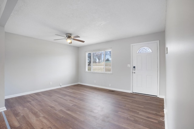 foyer entrance with a textured ceiling, wood finished floors, visible vents, a ceiling fan, and baseboards