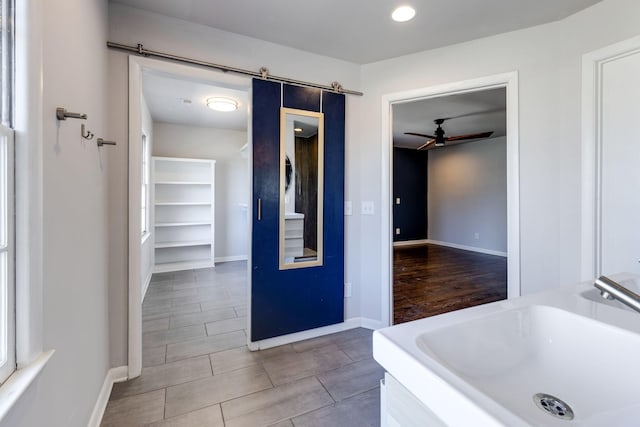 bathroom featuring a ceiling fan, baseboards, and a sink